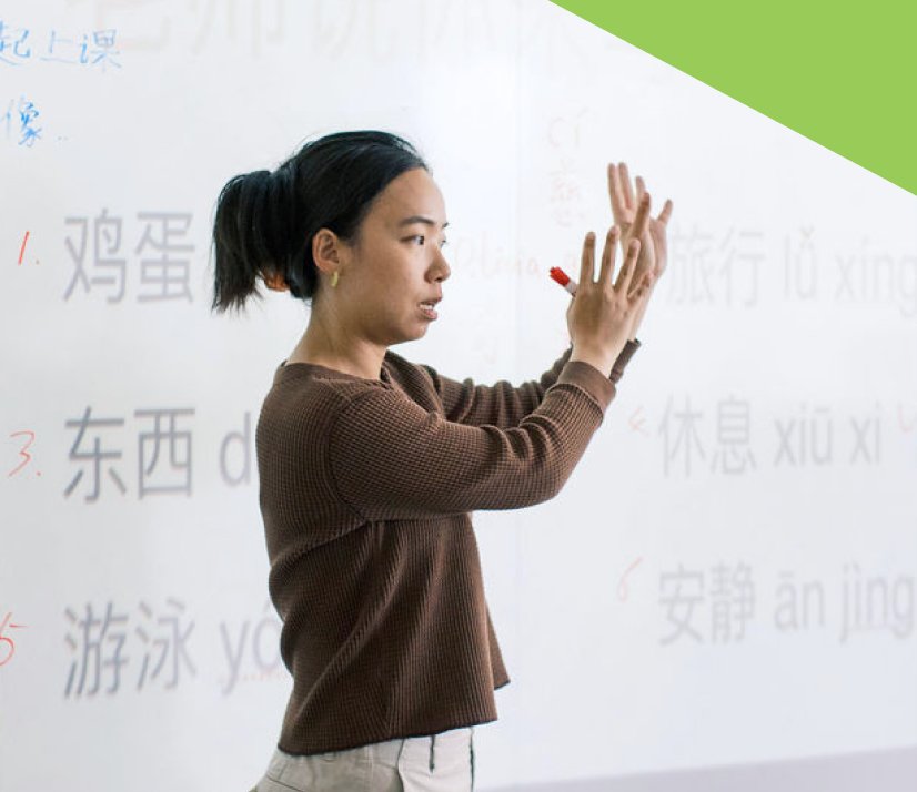 A teacher writing Mandarin characters on a whiteboard at Presidio Knolls School
